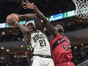 Milwaukee Bucks guard Jrue Holiday (21) grabs a rebound against Toronto Raptors forward Pascal Siakam.