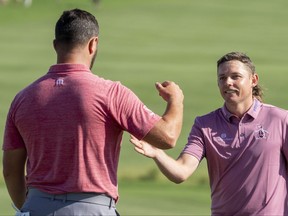 Cameron Smith (right) is congratulated by Jon Rahm (left) after Smith won on the 18th hole during the final round of the Sentry Tournament of Champions golf tournament at Kapalua Resort.