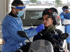 A medic gets a swab sample from a man at a drive-thru testing site for the coronavirus, in the central Israeli city of Modiin, on Jan. 2, 2022.