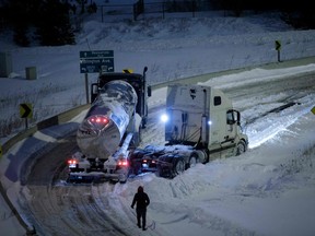 Trucks caught in the snow sit on the off-ramp to Highway 401 in Toronto on January 17, 2022.
