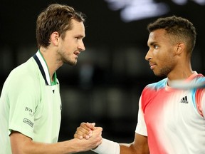 Russia's Daniil Medvedev (L) shakes hands with Canada's Felix Auger-Aliassime after their  men's singles quarter-final match on day ten of the Australian Open tennis tournament in Melbourne on January 27, 2022.