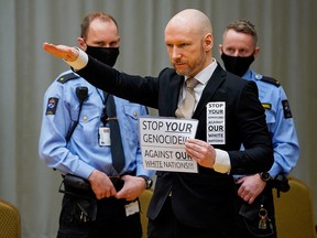 Anders Behring Breivik raises his arm to make a Nazi salute as he arrives on the first day of the trial where he is requesting release on parole, on January 18, 2022 at a makeshift courtroom in Skien prison, Norway.