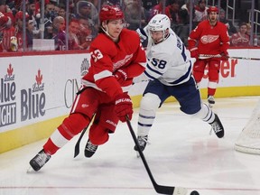 Detroit Red Wings’ Moritz Seider and the Leafs’ Michael Bunting fight for the puck in Detroit last night.  Getty Images