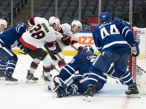 Ottawa Senators right wing Connor Brown watches as teammate Alex Formenton (top) tries, but fails to slide the puck past Toronto Maple Leafs goaltender Jack Campbell at Scotiabank Arena. USA TODAY Sports