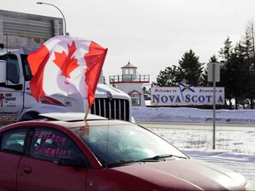 A truck passes by the Canadian truck convoy/protest along the New Brunswick-Nova Scotia border in Fort Lawrence, N.S., Jan. 23, 2022