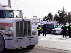 A truck passes by the Canadian truck convoy/protest along the New Brunswick-Nova Scotia border in Fort Lawrence, N.S, Jan. 23, 2022.