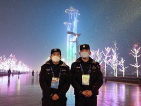 Two Chinese police wears a protective mask as they stands in front of the Olympic Tower ahead of the Beijing Winter Olympics on Jan. 30, 2022 in Beijing.
