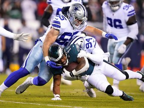 Kenneth Gainwell of the Philadelphia Eagles runs for a first down as Leighton Vander Esch and Randy Gregory of the Dallas Cowboys defend at Lincoln Financial Field on January 8, 2022 in Philadelphia.