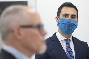 Ontario Education Minister Stephen Lecce looks over at Dr. Kieran Moore, Ontario’s Chief Medical Officer of Health, during a news conference in Toronto on Thursday, November 18, 2021. CHRIS YOUNG/THE CANADIAN PRESS