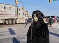 Protesters of COVID-19 restrictions, and supporters of Canadian truck drivers protesting the COVID-19 vaccine mandate cheer on a convoy of trucks on their way to Ottawa, on the Trans-Canada Highway west of Winnipeg, Manitoba, Tuesday January 25, 2022.