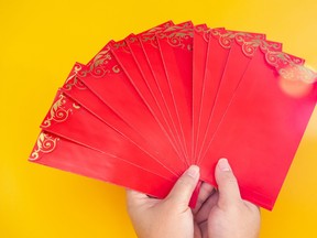 Tet Holiday.Lunar New Year.Chinese New Year . Woman hand holding a pack of red envelope