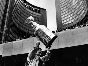 Toronto Maple Leaf captain George Armstrong holds the Stanley Cup at City Hall in this file photo.