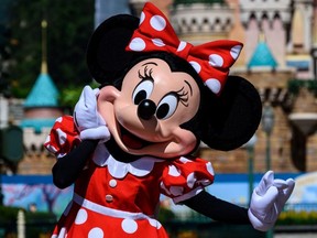 A cast member dressed as cartoon character Minnie Mouse takes part in the official reopening ceremony of Hong Kong's Disneyland on June 18, 2020,