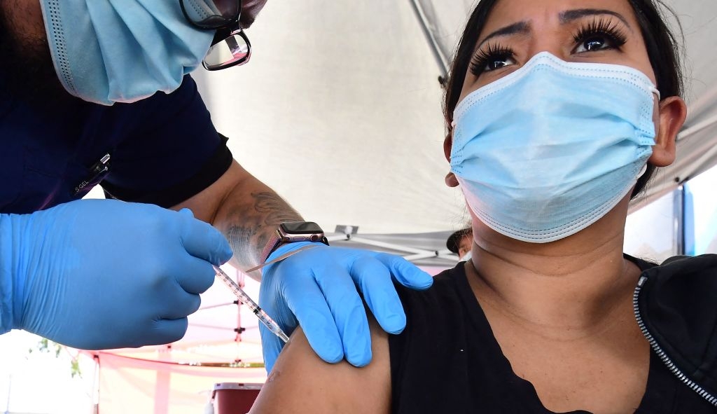 Carmen Penaloza receives her first dose of the Pfizer Covd-19 vaccine at a pop-up clinic offering vaccines and booster shots in Rosemead, California on November 29, 2021.(Photo by Frederic J. BROWN / AFP) (Photo by FREDERIC J. BROWN/AFP via Getty Images)