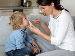 A mom tests her child for COVID at home.