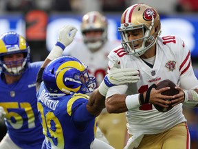 Aaron Donald  of the Los Angeles Rams attempts to sack Jimmy Garoppolo of the San Francisco 49ers in the second quarter of the game at SoFi Stadium on January 09, 2022 in Inglewood, California.