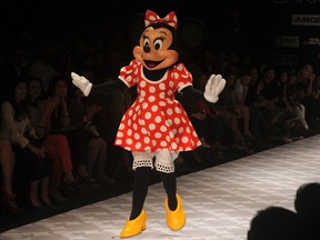 An artist dressed as Minnie Mouse performs during a show called ‘Memories of Mickey Mouse & Minnie Mouse’ by Indian designers Little Shilpa and Nitin Bal Chauhan on the second day of Lakme Fashion Week (LFW) in Mumbai on March 3, 2012. (Photo by PUNIT PARANJPE/AFP via Getty Images)