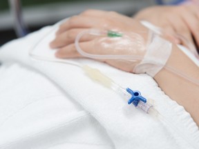 An IV needle on a patient in a hospital.