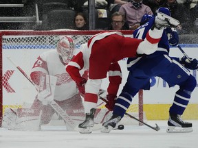 Red Wings goaltender Thomas Greiss makes a save as Maple Leafs forward Auston Matthews and Red Wings forward Pius Suter battle for the puck during first period NHL hockey action in Toronto on Saturday, October 30, 2021.
