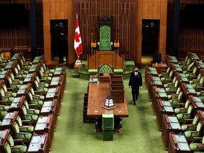 A page places calendars on the desks of Members of Parliament in the House of Commons before the opening of the 44th Parliament on November 22, in Ottawa, November 19, 2021.
