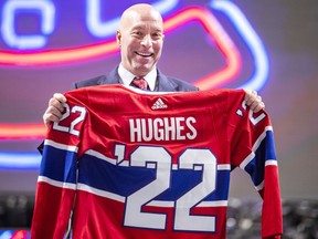 Kent Hughes holds up a jersey after being introduced as the Montreal Canadiens' new general manager on Wednesday in Montreal.