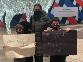 Lisa Baetz and her two sons, Jacob and William, attend a small demonstration against remote learning, at Hamilton's Lime Ridge Mall.