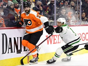 Philadelphia Flyers' Keith Yandle, left, and Dallas Stars' Luke Glendening battle along the boards Monday, Jan. 24, 2022, in Philadelphia.