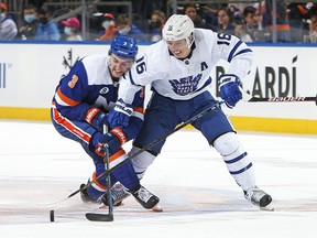 Mitch Marner (right) of the Maple Leafs holds off Adam Pelech of the New York Islanders during Toronto's 3-1 win on Saturday night. Marner had a shorthanded marker in the game.