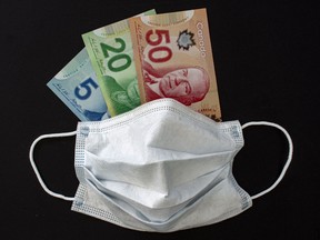 A Face Mask with Canadian Dollar bills on a black background.