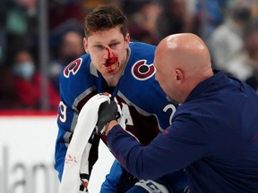 Colorado Avalanche center Nathan MacKinnon is treated for an injury in the first period against the Boston Bruins at Ball Arena in Denver, Jan. 26, 2022.
