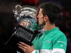 Novak Djokovic celebrates with the trophy after winning his ninth Australian Open title at Melbourne Park, Australia, February 21, 2021.