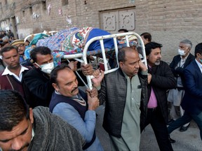 Christian devotees carry the coffin of a priest who was gunned down when driving back home after Sunday prayers in Peshawar on Jan. 30, 2022.