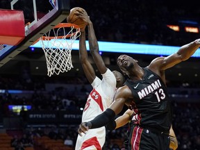 Raptors' forward Chris Boucher (left) dunks over Miami Heat's Bam Adebayo during the first half on Monday, Jan. 17, 2022, in Miami.