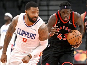 Toronto Raptors forward Pascal Siakam (43) brings the ball up court behind Los Angeles Clippers forward Marcus Morris (8) in the first half at Scotiabank Arena.