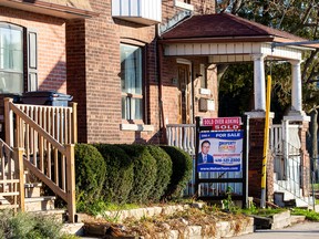 A for sale sign is displayed outside a home in Toronto, Dec. 13, 2021.