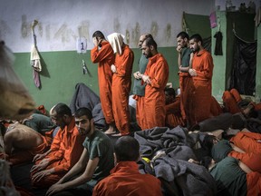 This file photo taken on October 26, 2019, shows men suspected of being affiliated with the Islamic State (IS) group, praying in a cell of the Sinaa prison in the Ghwayran neighbourhood of the northeastern Syrian city of Hasakeh.
