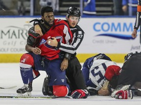 South Carolina Stingrays defenceman Jordan Subban, left, is held by a linesman after getting in a fight with Jacksonville Icemen defenceman Jacob Panetta on Saturday. The ECHL has suspended Panetta after Subban accused him of making a racial gesture.