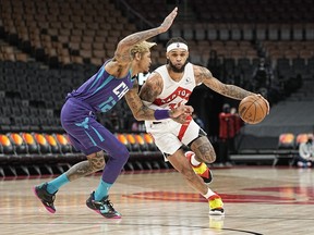 Raptors' Gary Trent Jr. dribbles the ball against Charlotte Hornets' Kelly Oubre Jr. during the second half at Scotiabank Arena on Tuesday, Jan. 25, 2022.