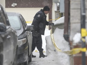A Toronto Police Forensic officer investigates on Monday, January 24, 2022, the day after a shooting on Avenue Rd. just south of College View Ave.