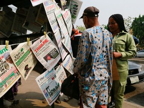 People stand next to a newspaper stand after Nigeria government announced the lifting of Twitter ban, in Abuja, Nigeria January 13, 2022.