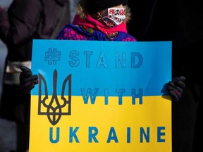 A participant holds a placard during a rally in support of Ukraine and against Russia, in Niagara Falls, Ont., Sunday, Jan. 30, 2022.