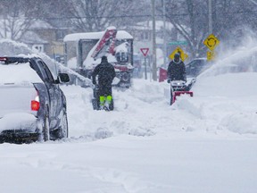 Homeowners attempt to clear snow from driveways on Jan. 17, 2022, in Ajax, Ont.