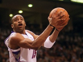 Toronto Raprtors' Vince Carter scores on 360° after a steal from Sacramento Kings' Vlade Divac (background), during the first quater NBA game in Toronto on February 23, 2001. Carter received a standing ovation from spectators for the play.