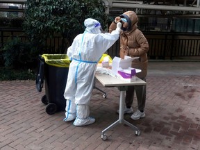 A resident undergoes a nucleic acid test for COVID-19 in Xian, in China's northern Shaanxi province, Friday, Jan. 14, 2022.