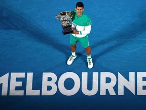 In this file photo taken on February 21, 2021, Serbia's Novak Djokovic holds the Norman Brookes Challenge Cup trophy after beating Russia's Daniil Medvedev to win their men's singles final match on day fourteen of the Australian Open tennis tournament in Melbourne.
