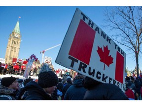 Supporters of the Freedom Convoy stand in front of the Parliament Buildings as truckers take part in a convoy to protest COVID-19 vaccine mandates for cross-border truck drivers in Ottawa, Jan. 29, 2022.
