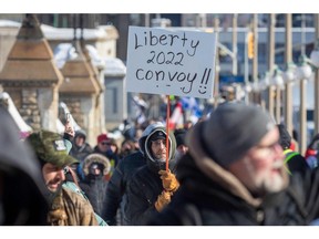 Supporters of the Freedom Convoy stand in front of the Parliament Buildings as truckers take part in a convoy to protest COVID-19 vaccine mandates for cross-border truck drivers in Ottawa, Jan. 29, 2022.