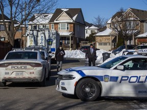 Peel Regional Police at a scene on Redcastle St. in Brampton, Ont. after two people were found dead in a vehicle outside a home on Thursday, Jan. 20, 2022.