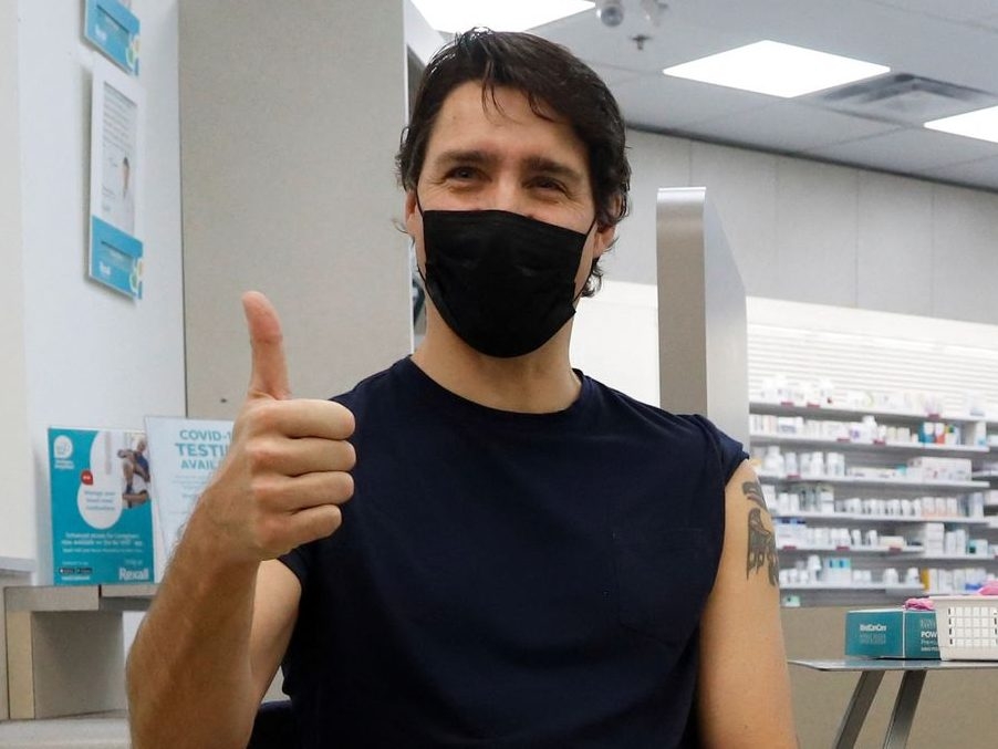 Prime Minister Justin Trudeau reacts after receiving his booster injection of a COVID-19 vaccine at a pharmacy in Ottawa, Jan. 4, 2022.  