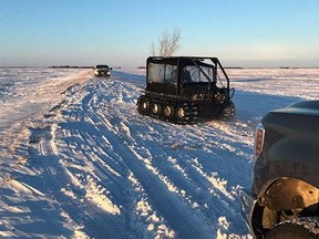 Snow and vehicles are seen as RCMP officers search the area where a family of four froze to death after crossing the border from the U.S. near Emerson, Manitoba, Canada, in this January 19, 2022 handout photo.